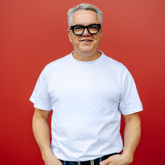 A person standing in front of a red background