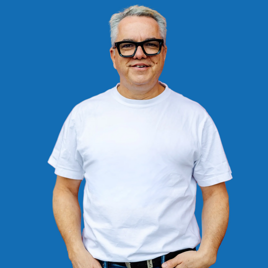 A person standing against a blue background
