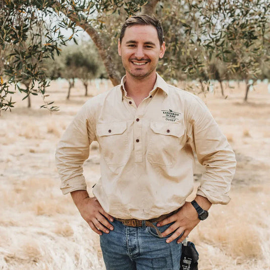 A man standing on an olive orchard
