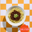 Bowl of ramen with green onions on a checkered orange and white background, featuring the Nourish Little Lives logo.