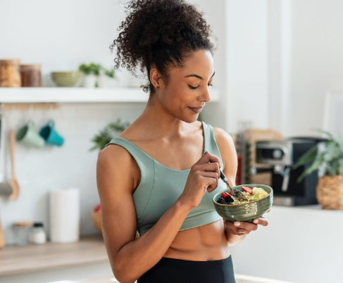 Woman eating a healthy meal in a kitchen