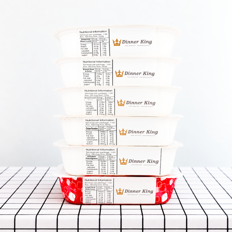 A stack of packaged meals from Dinner King on a table