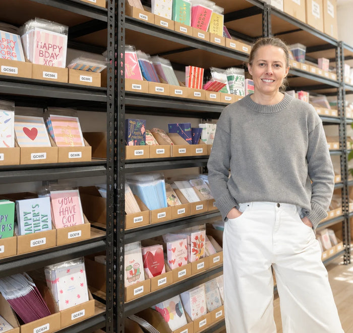 Ella from Elm Paper stand in front of cards