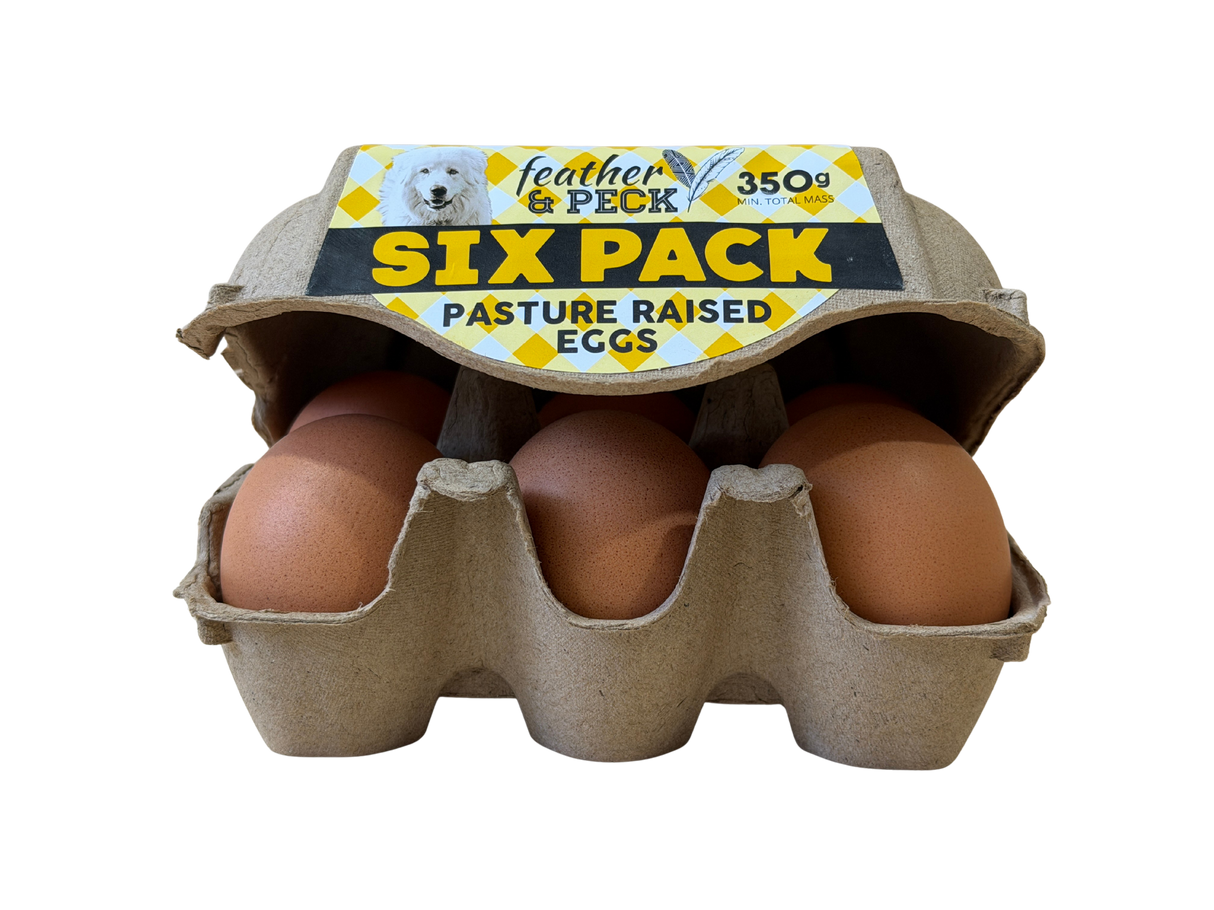 Six-pack of pasture-raised eggs in a cardboard carton with 'feather & peck' branding.